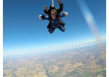 Austin Elmer poses for a photo mid-air while tandem skydiving