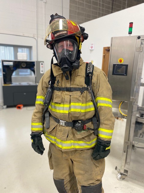 Man dressed in full firefighter outfit and gear